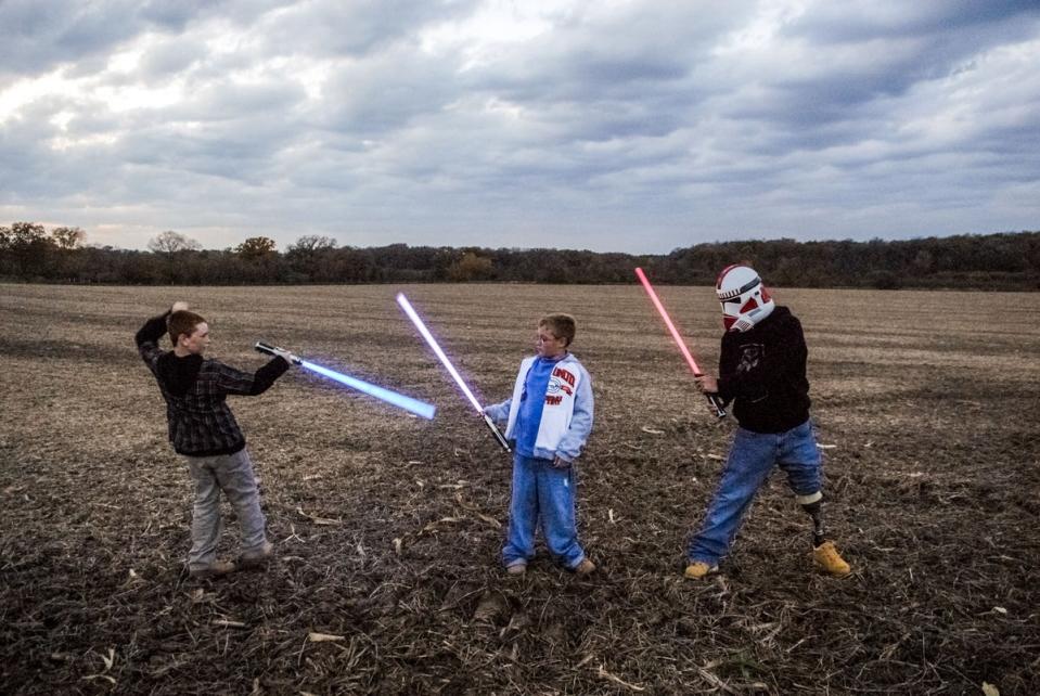 Raymond Hubbard, who lost his leg to a rocket attack in Iraq on 4 July 2006, plays Star Wars with his sons Brady and Riley in Darien, Wisconsin in 2007. (Peter van Agtmael/Magnum Photos)