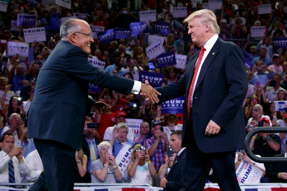 Giuliani shakes hands with Trump at a campaign rally in August 2016 (AP)