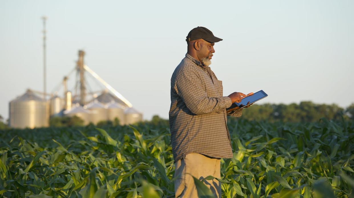 Calculating the cost of living in the country. <a href="https://www.gettyimages.com/detail/photo/black-farmer-with-digital-tablet-in-crop-field-royalty-free-image/463245219?phrase=rural%20america&adppopup=true" rel="nofollow noopener" target="_blank" data-ylk="slk:Ariel Skelley/Getty Images;elm:context_link;itc:0;sec:content-canvas" class="link ">Ariel Skelley/Getty Images</a>