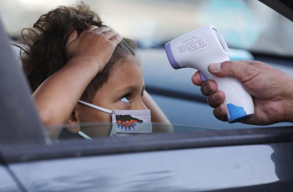 A student receives a temperature check before leaving the car to enter STAR Eco Station Tutoring & Enrichment Center on September 2, 2020 in Culver City, California