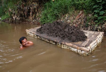 A worker collects sand from the bottom of the Citarum river in order to make bricks, near Majalay, south-east of Bandung, West Java province, Indonesia, January 26, 2018. REUTERS/Darren Whiteside