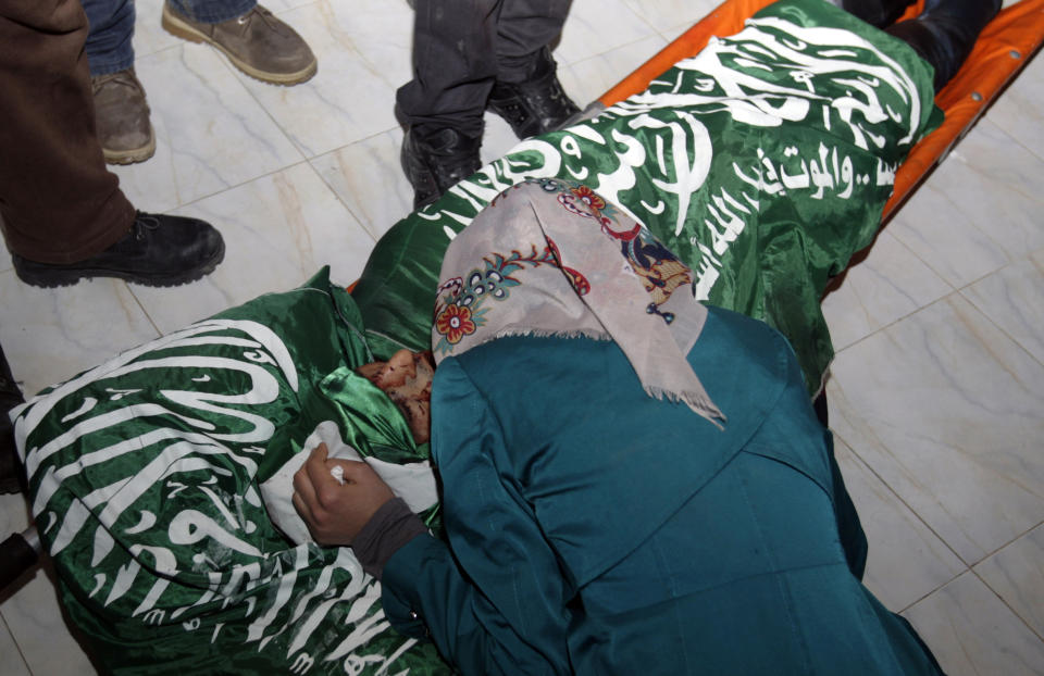 Relatives of Hamza Abu el-Heija, who was killed by Israeli troops, mourn over his body in the West Bank refugee camp of Jenin, Saturday, March 22, 2014. Israeli troops killed at least four Palestinians in an early morning raid that was followed by a clash with angry protesters in a West Bank town on Saturday, the Israeli military and Palestinian security officials said, in the deadliest incident in months. The Israeli military said the raid aimed to arrest Hamza Abu el-Heija, a 22-year-old Hamas operative wanted for involvement in shooting and bombing attacks against Israelis. (AP Photo/Mohammed Ballas)