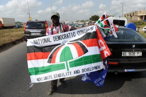 A vendor hawks flags of the ruling National Democratic Congress and New Patriotic Party in a traffic jam in Kasoa, Central Ghana omn Saturday. Free schooling is a tantalising offer in Ghana, where the World Bank estimates the average Ghanaian makes about $1,400 a year and the government says only about 14 percent of people finish high school