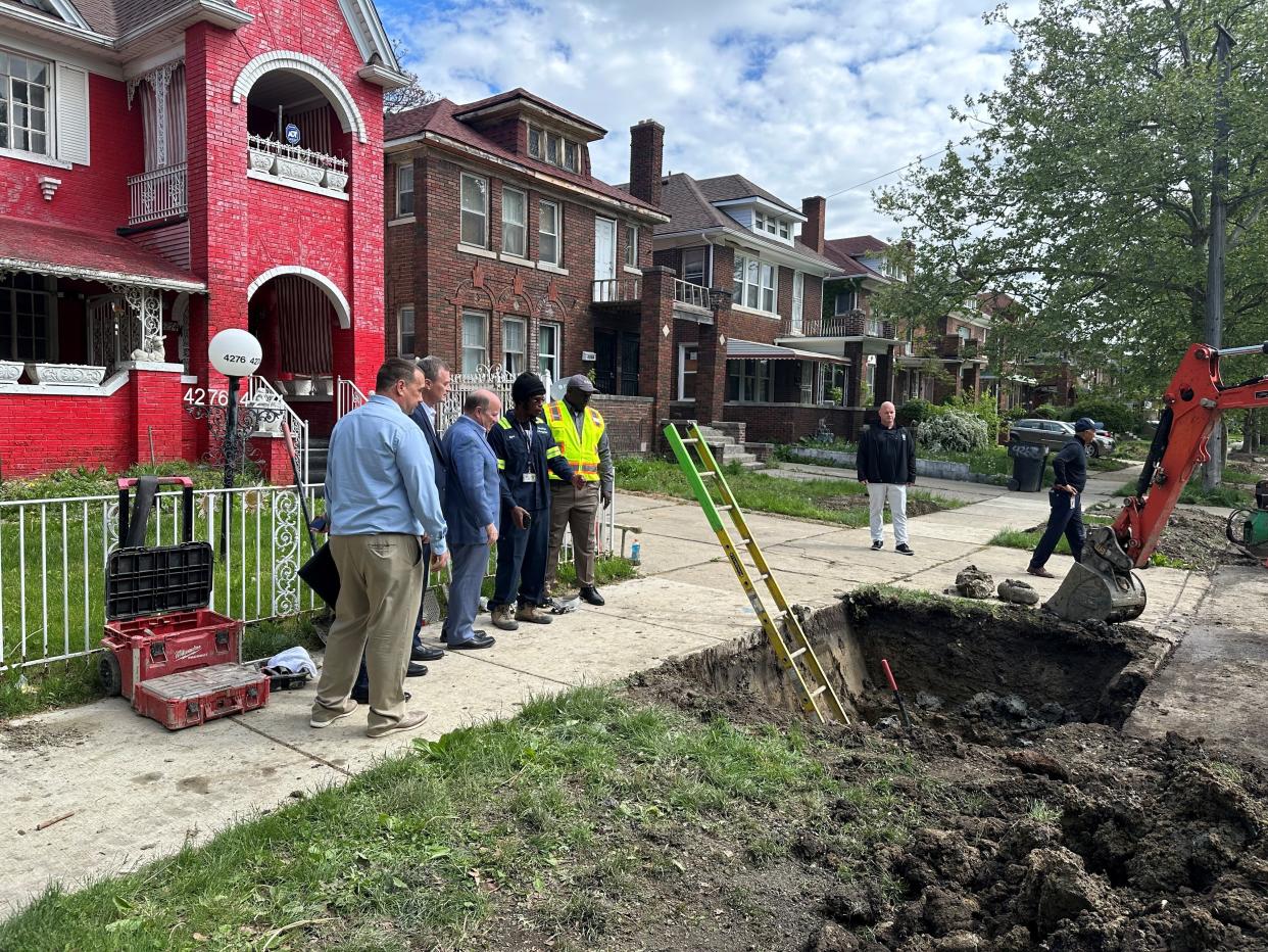 Darius Byrd, who replaces lead service lines, explains how to replace lead service lines with Mayor Mike Duggan and Phillip Roos, director of Michigan Department of Environment, Great Lakes and Energy, on Friday, May 10, in Detroit's Russell Woods neighborhood.