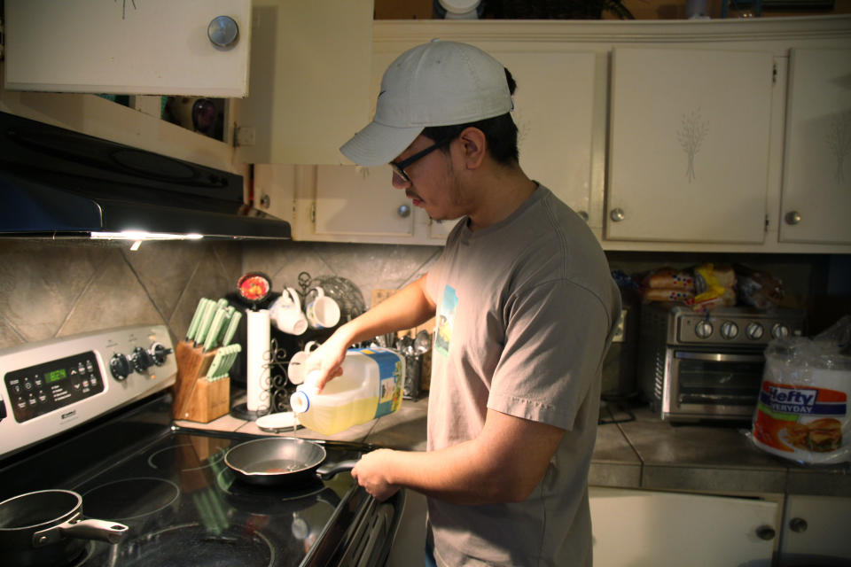 Samuel Alfaro, 19, starts to cook his breakfast at his home in Houston, Texas, Friday July 23, 2021. Alfaro said his appointment to obtain deferred action for childhood arrival or DACA immigration status was canceled due to a recent federal court ruling against the program. (AP Photo/John L. Mone)