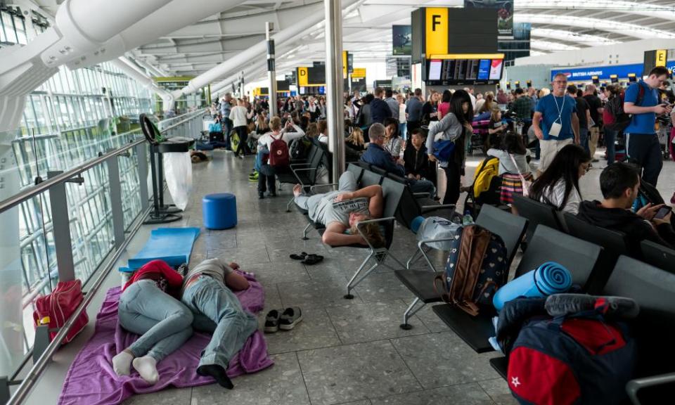 People sleep on a blanket at Heathrow airport’s terminal 5.