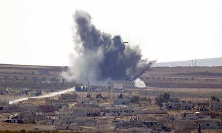 Smoke rises from the Syrian town of Kobani, seen from near the Mursitpinar border crossing on the Turkish-Syrian border in the southeastern town of Suruc in Sanliurfa province October 15, 2014. REUTERS/Kai Pfaffenbach