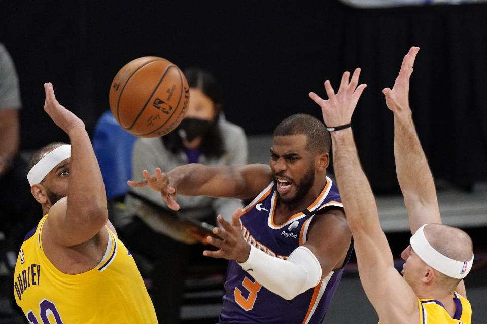 Phoenix Suns guard Chris Paul, center, passes the ball as Los Angeles Lakers forward Jared Dudley, left, and guard Alex Caruso defend during the first half of an NBA basketball game Tuesday, March 2, 2021, in Los Angeles. (AP Photo/Mark J. Terrill)