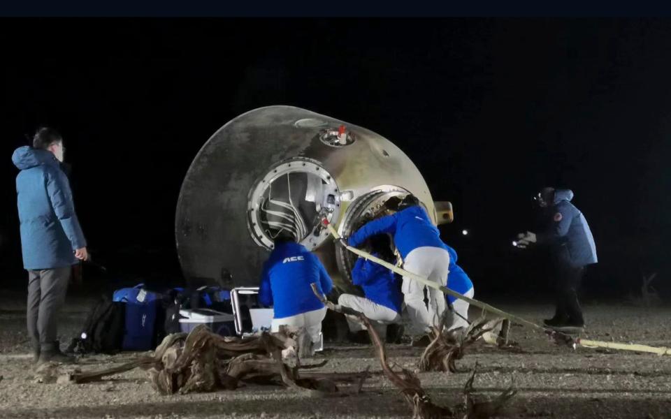 Ground crew check on the astronauts inside the re-entry capsule - Li Gang