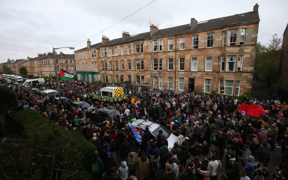 Police by an immigration van in Kenmure Street, Glasgow which is surrounded by protesters -  Andrew Milligan/PA