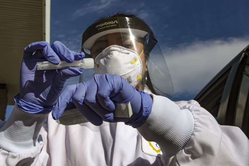 Ontario, CA - December 30: San Bernardino County Public Health Department nurse Marijorie Tabago collects nasal sample for COVID-19 testing at Convention Center on Wednesday, Dec. 30, 2020 in Ontario, CA. All county coronavirus testing sites will be closed on December 31 to January 01. They will reopen on Saturday January 02, 2021. (Irfan Khan / Los Angeles Times)