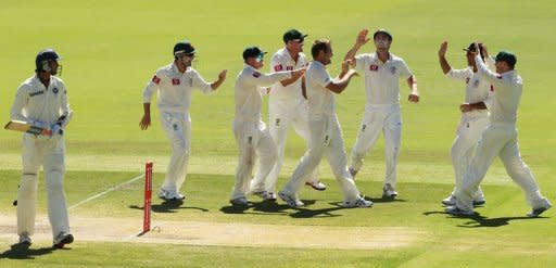 Indian batsman Ishant Sharma (L) leaves the oval as Australian players celebrate during their fourth Test on January 28. Sharma was out on the eighth ball of the last day, caught behind off Ryan Harris for two