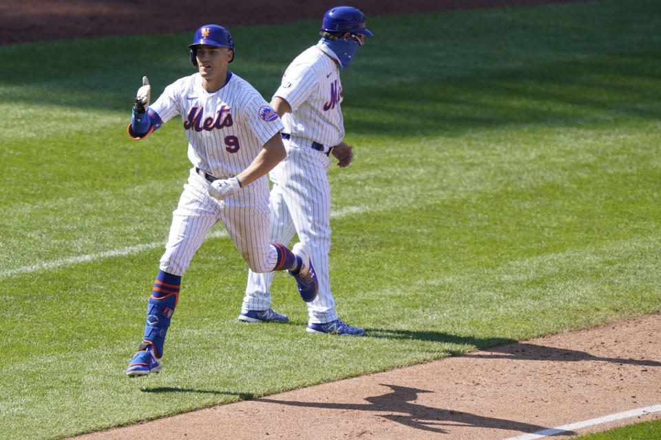 New York Mets Brandon Nimmo (9) gestures as he leaps past the Mets third base coach after hitting a solo home run during the sixth inning of a baseball game against the Philadelphia Phillies, Sunday, Sept. 6, 2020, in New York. (AP Photo/Kathy Willens)