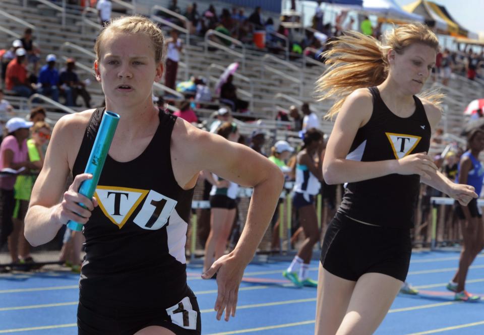 Tatnall anchor Reagan Anderson takes the baton from teammate Lindsay Voltz in the Division II 4x800-meter relay at the 2013 state meet.