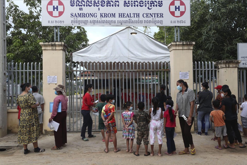 Children wait in front of Samrong Krom health center outside Phnom Penh, Cambodia, before their receive a shot of the Sinovac's COVID-19 vaccine Friday, Sept. 17, 2021. Prime Minister Hun Sen announced the start of a nationwide campaign to give COVID-19 vaccinations to children between the ages of 6 and 11 so they can return to school safely after a long absence due to measures taken against the spread of the coronavirus. (AP Photo/Heng Sinith)