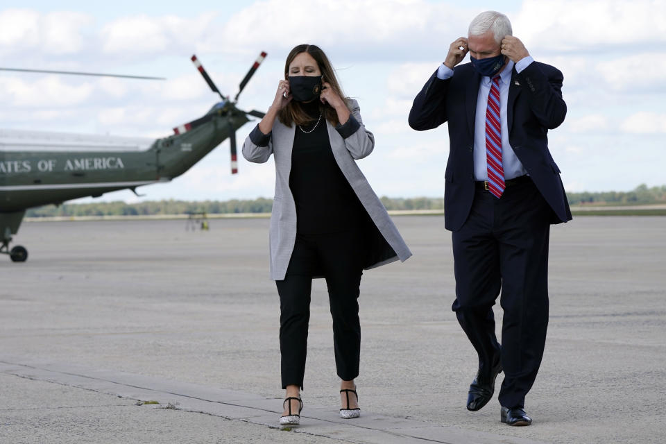 Vice President Mike Pence and his wife Karen remove their face coverings before speaking to members of the media at Andrews Air Force Base, Md., Monday, Oct. 5, 2020, as he leaves Washington for Utah ahead of the vice presidential debate. (AP Photo/Jacquelyn Martin)