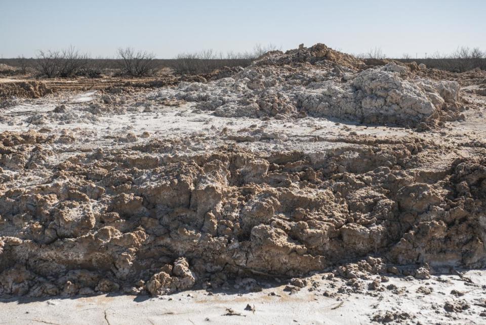 Soil tinged white from high levels of salt caused by the leaking well is seen Saturday, Feb. 24, 2024, on Bill Wight’s land in Crane County.