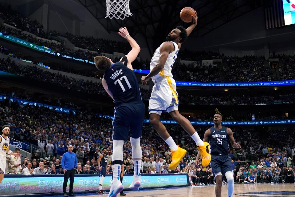 Golden State Warriors forward Andrew Wiggins (22) dunks the ball over Dallas Mavericks guard Luka Doncic (77) during the second half of Game 3 of the NBA basketball playoffs Western Conference finals, Sunday, May 22, 2022, in Dallas. (AP Photo/Tony Gutierrez)