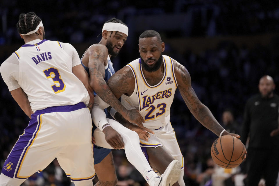 Los Angeles Lakers forward LeBron James (23) drives against Minnesota Timberwolves guard Nickeil Alexander-Walker, center, through a screen set by forward Anthony Davis (3) during the first half of an NBA basketball game in Los Angeles, Sunday, March 10, 2024. (AP Photo/Eric Thayer)