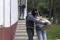 In this photo taken from video released by Belarusian KGB, State TV and Radio Company of Belarus on Wednesday, July 29, 2020, Belarusian KGB officers detain Russian men in a sanitarium outside in Minsk, Belarus. Belarusian officials said that more than 30 detained employees of private Russian military contractor Wagner are facing a criminal probe on charges of plotting terror attacks in Belarus amid a presidential election campaign. (Belarusian KGB, State TV and Radio Company of Belarus via AP)