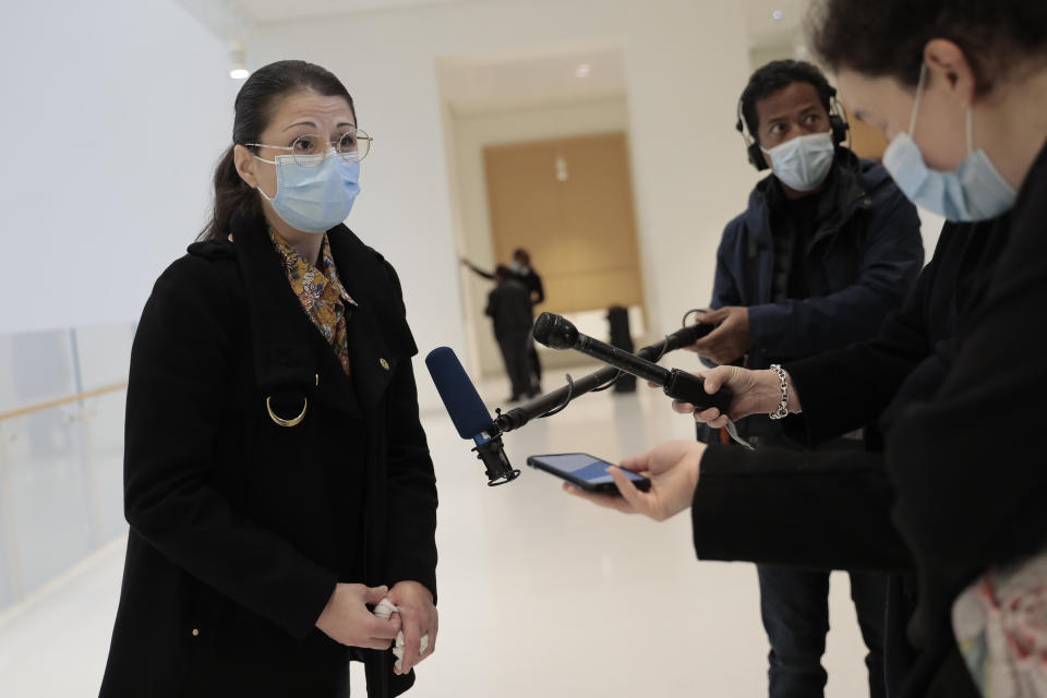 Plaintiff Sabrina Deliry answers reporters before the start of a hearing at the Paris Palace of Justice, Wednesday, March 3, 2021. A Paris court holds a hearing Wednesday in a class-action effort to hold French health authorities and companies accountable after thousands of people with the virus died in nursing homes, and families were locked out and left in the dark about what was happening to their isolated loved ones. Sabrina Deliry has mobilized families around France since her mother's Paris nursing home was first locked down a year ago. (AP Photo/Lewis Joly)