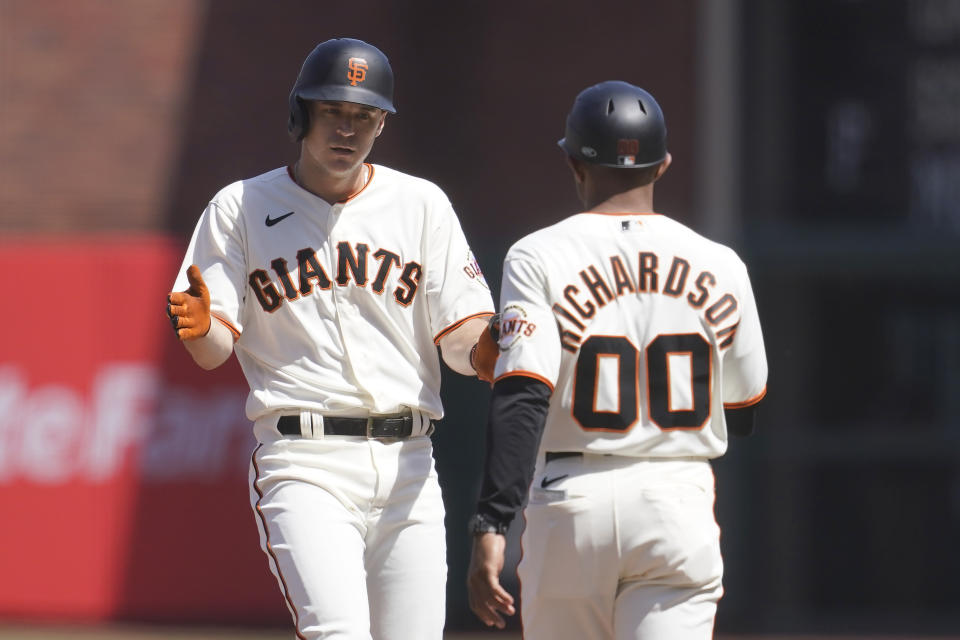 San Francisco Giants' Jason Krizan, left, is congratulated by first base coach Antoan Richardson (00) after hitting a single against the Washington Nationals during the fifth inning of a baseball game in San Francisco, Sunday, May 1, 2022. (AP Photo/Jeff Chiu)