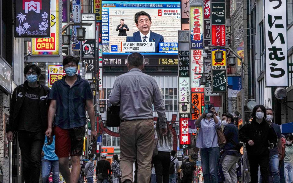 People walk through a street of Kabukicho, Japan's biggest nightlife entertainment district at Shinjuku in Tokyo, Japan, 25 May 2020 - Shutterstock