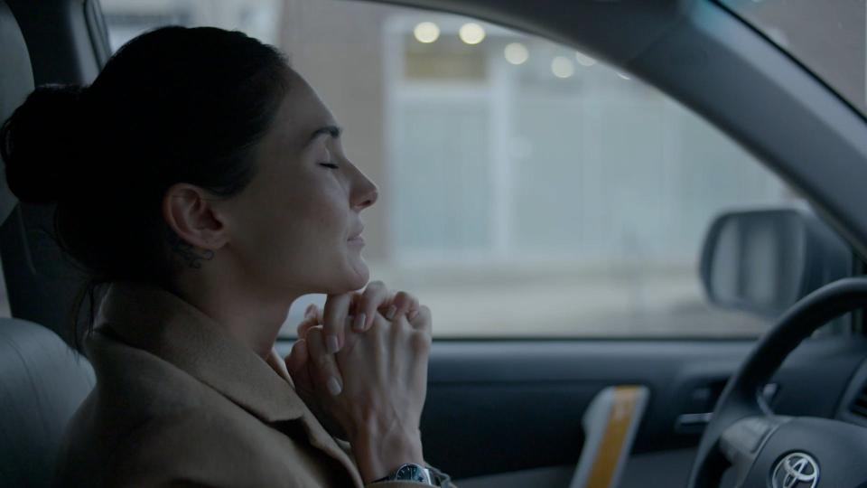 Saffron Cassaday clasping hands under chin in her car.