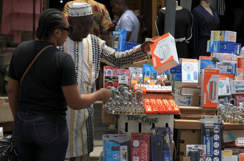 A vendor attends to a customer at his stall in Balogun market in Nigeria's commercial capital, Lagos