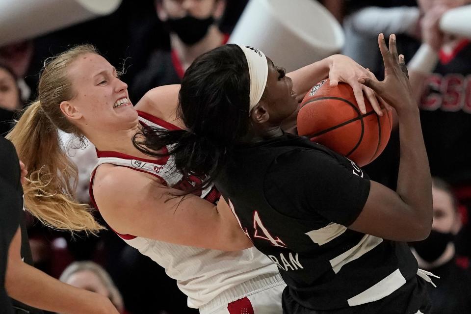 North Carolina State center Elissa Cunane, left, and Louisville forward Olivia Cochran reach for a rebound during the second half of an NCAA college basketball game in Raleigh, N.C., Thursday, Jan. 20, 2022. (AP Photo/Gerry Broome)