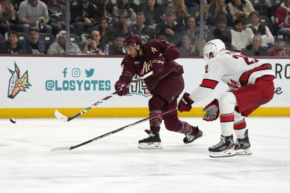 Arizona Coyotes center Nick Schmaltz (8) shoots in front of Carolina Hurricanes defenseman Brett Pesce during the third period of an NHL hockey game Friday, March 3, 2023, in Tempe, Ariz. The Hurricanes won 6-1. (AP Photo/Rick Scuteri)