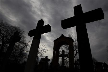 Stone crosses and gravestones are silhouetted against the sky at Invaliden cemetery in Berlin March 17, 2014. A simple plaque marks the forsaken spot where the Red Baron was buried in central Berlin but hardly anyone stops to remember the flying ace shot down in 1918. REUTERS/Tobias Schwarz