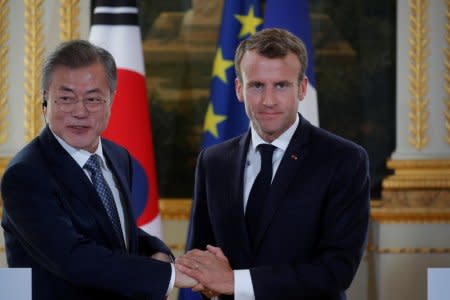 French President Emmanuel Macron and South Korean President Moon Jae-in shake hands during a joint news conference at the Elysee Palace in Paris, France, October 15, 2018.    REUTERS/Philippe Wojazer/Pool