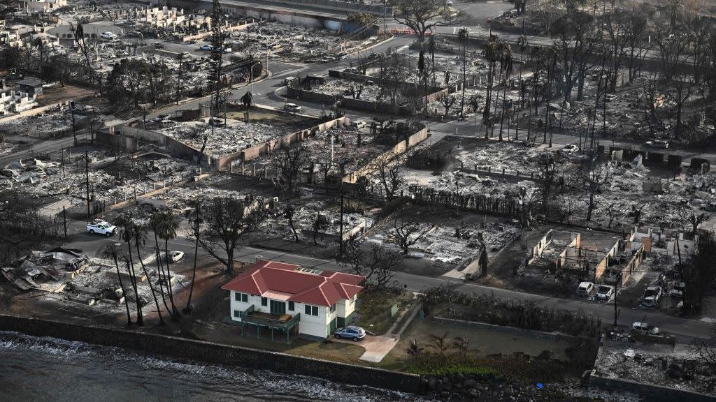 an aerial image shows a red roofed house that survived the fires surrounded by destroyed homes and buildings burned to the ground in the historic lahaina in the aftermath of wildfires in western maui in lahaina, hawaii on august 10, 2023 embattled officials in hawaii who have been criticized for the lack of warnings as a deadly wildfire ripped through a town insisted on august 16 that sounding emergency sirens would not have saved lives at least 110 people died when the inferno levelled lahaina last week on the island of maui, with some residents not aware their town was at risk until they saw flames for themselves photo by patrick t fallon afp photo by patrick t fallonafp via getty images
