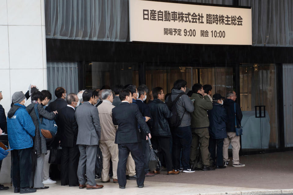 FILE - In this April 8, 2019, file photo released by Nissan Motor Co., Nissan shareholders wait to enter the venue for a meeting in Tokyo. Nissan is seeing sales and profits tumble, as its once revered former chairman, Carlos Ghosn, awaits trial on charges of financial misconduct. The Japanese automaker says it is beefing up corporate governance and sticking with its alliance with French partner Renault SA. The signs reads " Nissan Motor Corporation shareholders' meeting." (Nissan Motor Co. via AP, File)