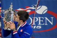 Novak Djokovic kisses the U.S. Open trophy in New York, September 13, 2015. REUTERS/Carlo Allegri