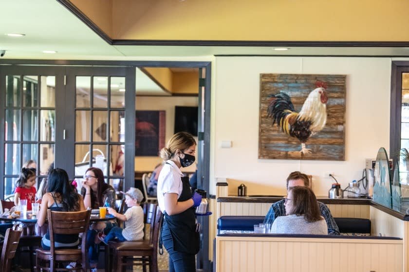 NORCO, CA - MAY 19: The scene inside The Original Pancake House on Tuesday, May 19, 2020 in Norco, CA. Owner Vince Kikugawa opened the doors to dine in customers last week and says he's taking every precaution possible and following CDC guidelines. Some of the changes to his restaurant include: limiting the amount of seating, washable menus, sanitizing each table thoroughly-this includes sanitizing the backs of seats, having patrons wait outside or in their cars until a seat is available, as well as face covering and gloves for all staff members. (Mariah Tauger / Los Angeles Times)