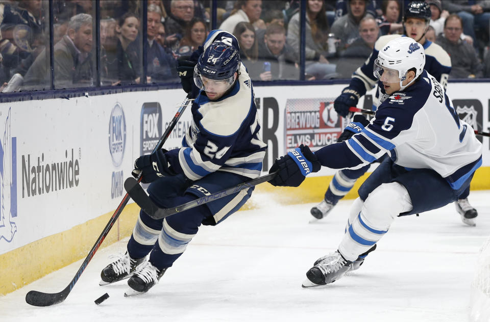 Columbus Blue Jackets' Nathan Gerbe, left, looks for an open pass as Winnipeg Jets' Luca Sbisa, of Italy, defends during the second period of an NHL hockey game Wednesday, Jan. 22, 2020, in Columbus, Ohio. (AP Photo/Jay LaPrete)