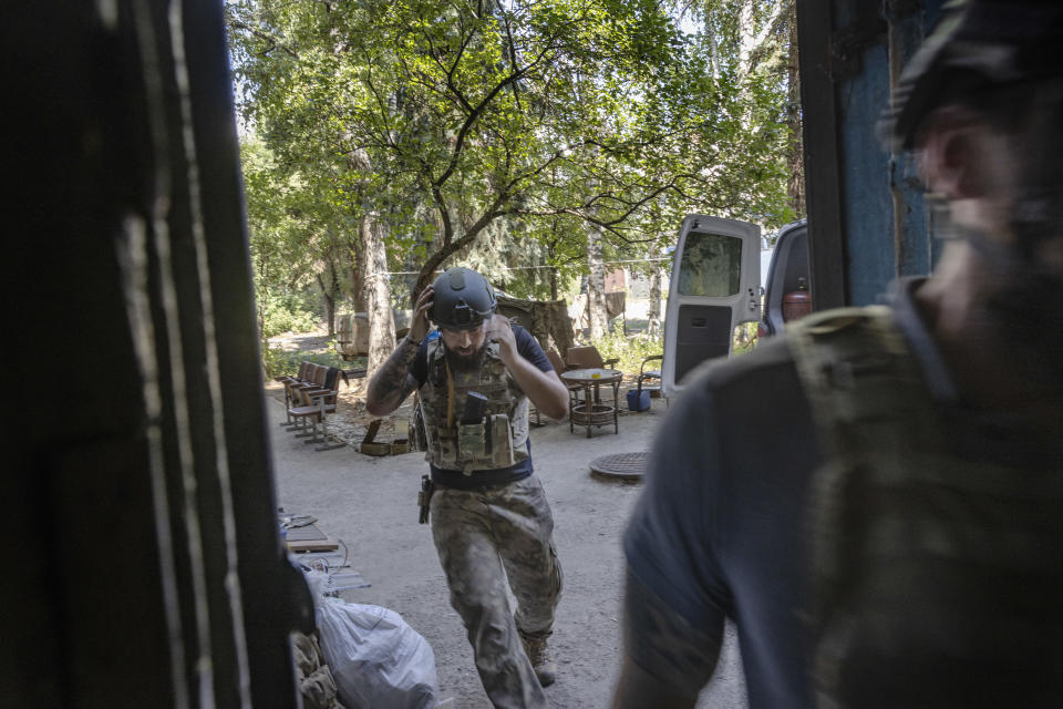 Un soldado ucraniano corre para cubrirse dentro de una base de avanzada mientras los cohetes rusos impactan cerca de Bajmut, Ucrania, el 10 de agosto de 2022. (David Guttenfelder/The New York Times)