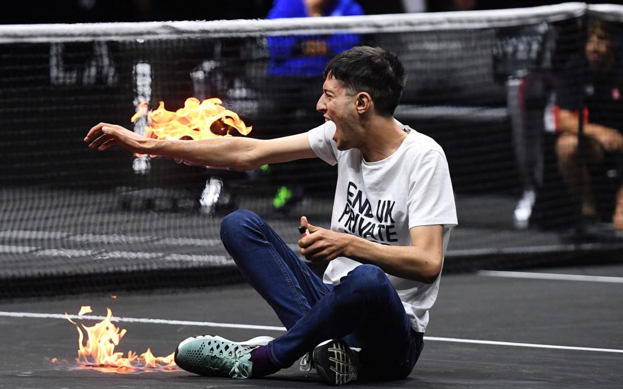 A climate change activist protests against UK private jets while lighting his right arm on fire during the Laver Cup tennis tournament at the O2 Arena in London, Britain, 23 September 2022 - ANDY RAIN/EPA-EFE/Shutterstock 