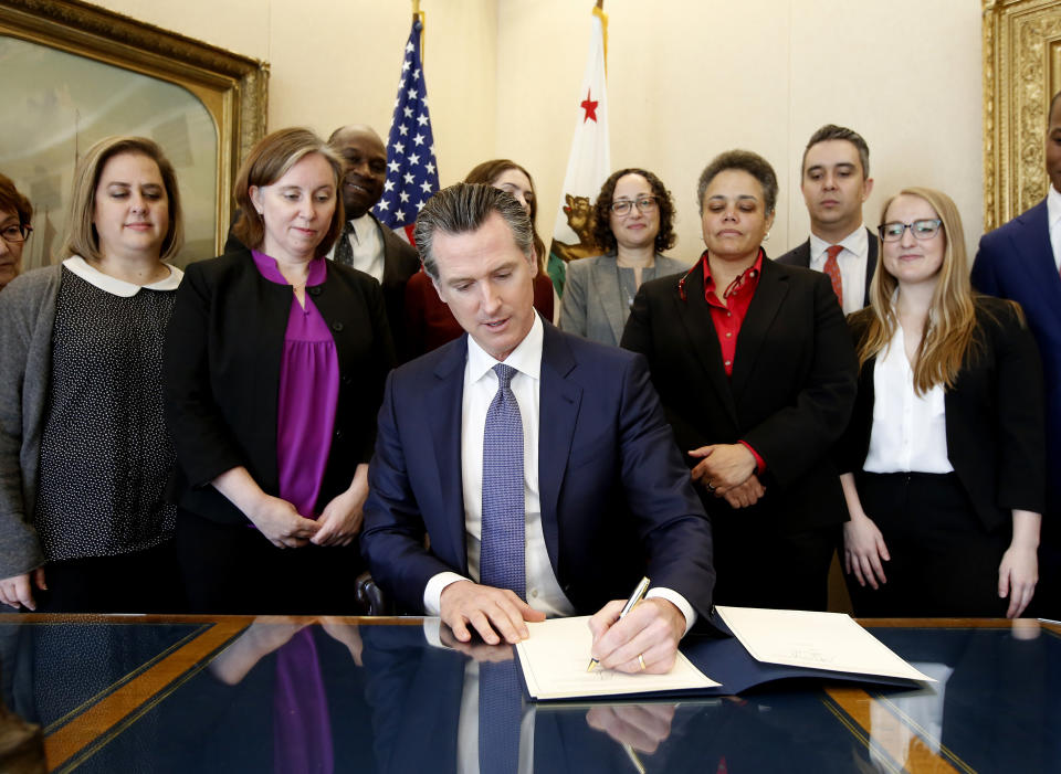 Gov. Gavin Newsom signs the executive order placing a moratorium on the death penalty at his Capitol office Wednesday, March 13, 2019, in Sacramento, Calif. (AP Photo/Rich Pedroncelli)