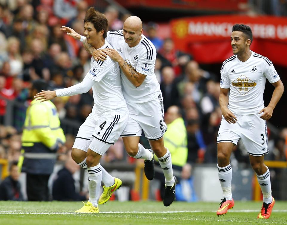 Swansea City's Ki celebrates with team mates after scoring a goal against Manchester United during their English Premier League soccer match at Old Trafford in Manchester