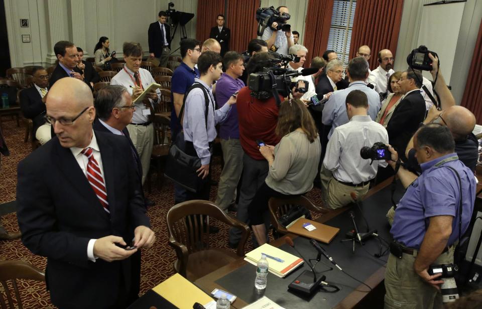 Michael Drewniak, left, chief spokesman for Gov. Chris Christie, waits to appear before the state legislature's Select Committee on Investigation Tuesday, May 13, 2014, in Trenton, N.J., which is probing the politically motivated closure of access lanes to the George Washington Bridge in Fort Lee last September. Republicans on the committee talk with the media at right. (AP Photo/Mel Evans)