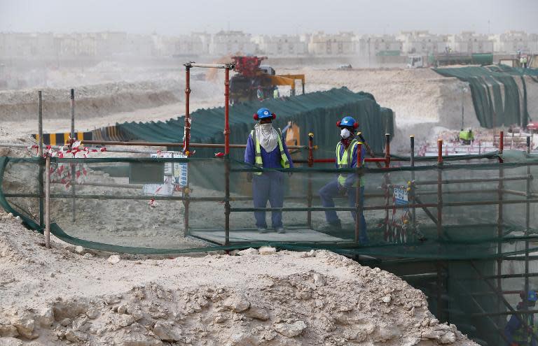 Foreign laborers work at the construction site of the al-Wakrah football stadium, one of the Qatar's 2022 World Cup stadiums, on May 4, 2015, in Doha