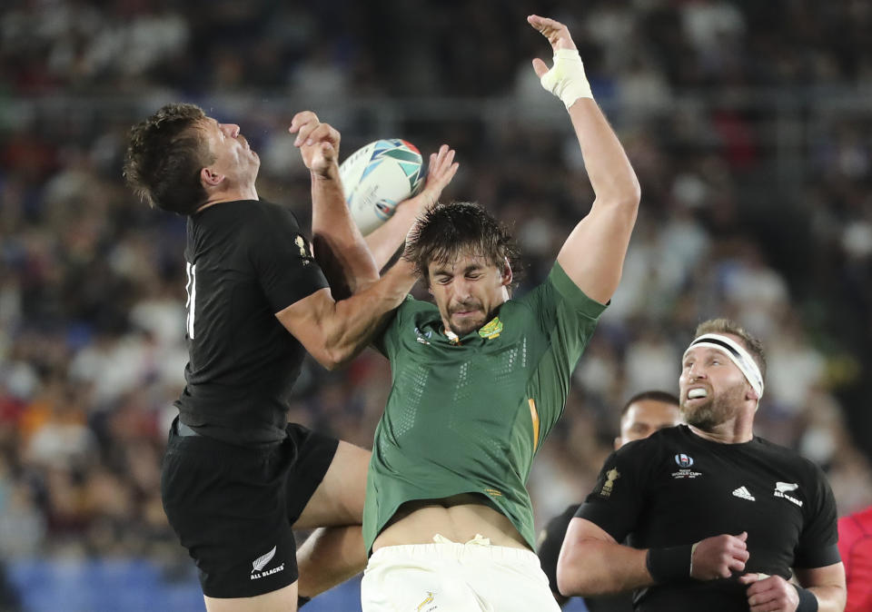 New Zealand's George Bridge, left, taps the ball against South Africa's Eben Etzebeth during the Rugby World Cup Pool B game at International Stadium in Yokohama, Japan, Saturday, Sept. 21, 2019. (AP Photo/Koji Sasahara)