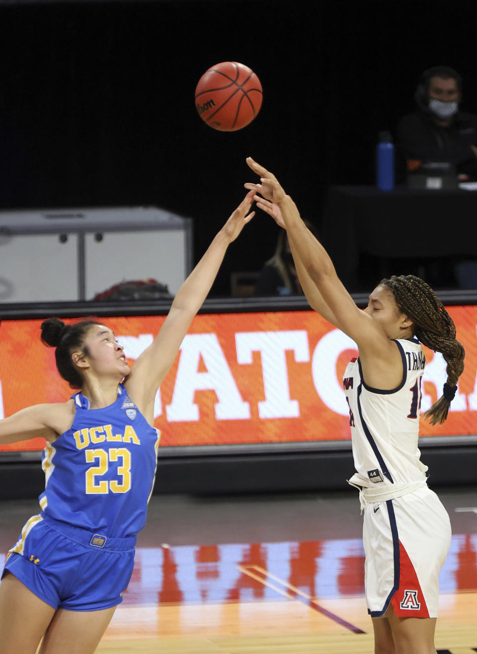 Arizona forward Sam Thomas (14) shoots as UCLA guard Natalie Chou (23) defends during the first half of an NCAA college basketball game in the semifinals of the Pac-12 women's tournament Friday, March 5, 2021, in Las Vegas. (AP Photo/Isaac Brekken)