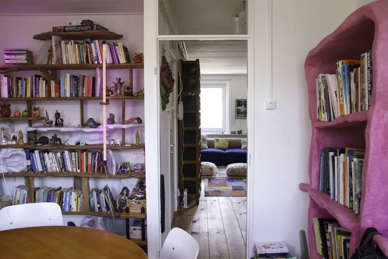 white dining room with bookshelves and view down hallway