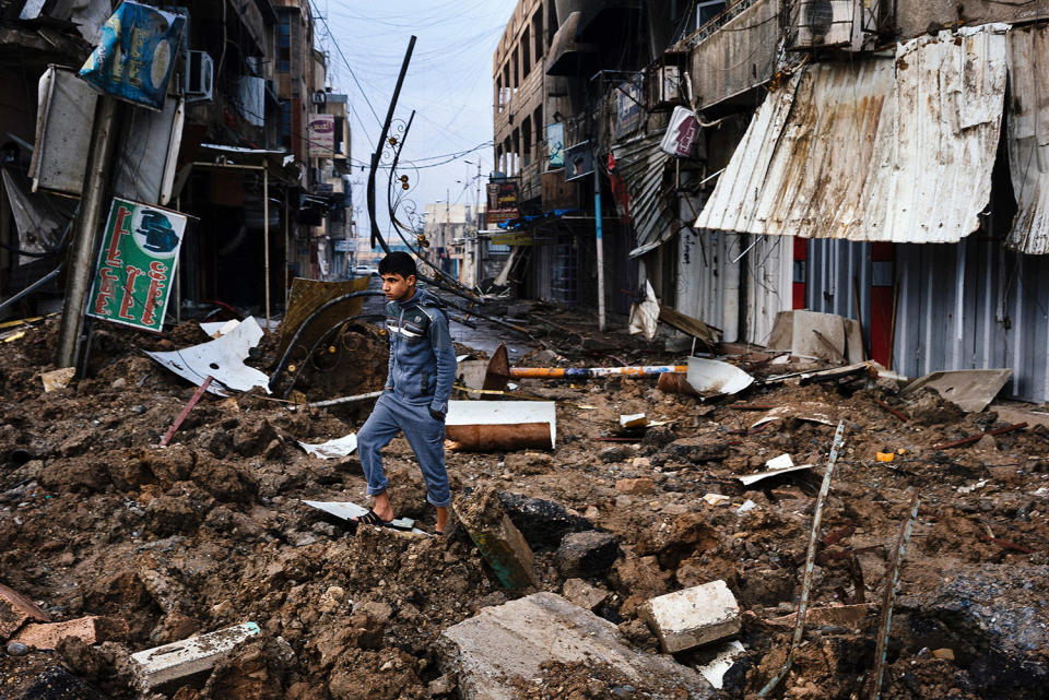 Iraqi boy walks among debris