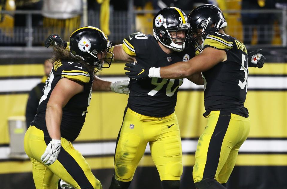 T.J. Watt (90) celebrates with teammates after forcing a fumble by Seahawks quarterback Geno Smith.