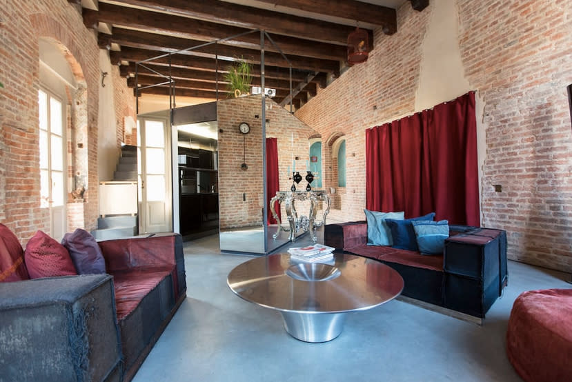 <p>Here’s the living room with exposed brick and beautiful wood-beamed ceiling. (Airbnb) </p>